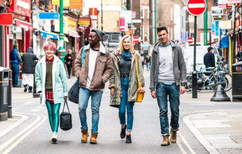 Multicultural students walking on Brick Lane center at Shoreditch London – Life style concept with multi-ethnic young friends on seasonal clothes having fun together outside – Bright vivid filter